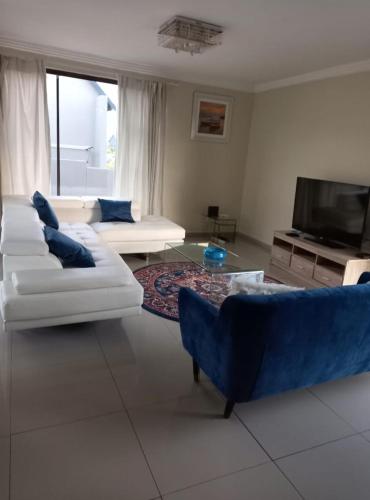 a living room with two couches and a tv at Mountain view in Hartbeespoort