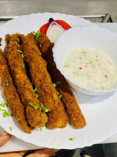 a plate of fried food with a bowl of dipping sauce at Bijou Hotel in Nairobi