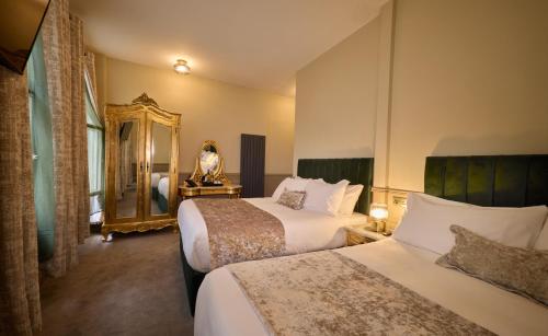une chambre d'hôtel avec deux lits et un miroir dans l'établissement Temple Bar Townhouse, à Dublin