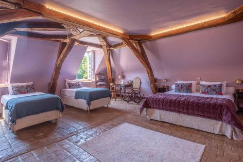 Un dormitorio con dos camas y una mesa y sillas. en Château de la Huberdière, en Nazelles