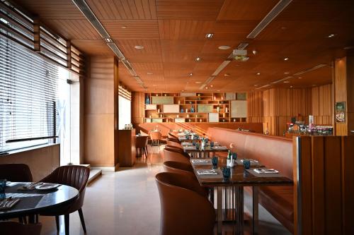 a dining room with tables and chairs in a restaurant at Holiday Inn New Delhi Mayur Vihar Noida by IHG in New Delhi