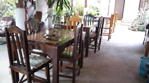 a dining room with a wooden table and chairs at Baan Songjum in Chiang Mai