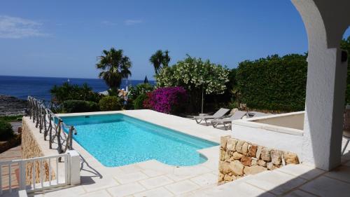ein Swimmingpool mit Blick auf das Meer in der Unterkunft Villa en primera linea de mar cerca de Binibeca in Sant Lluís
