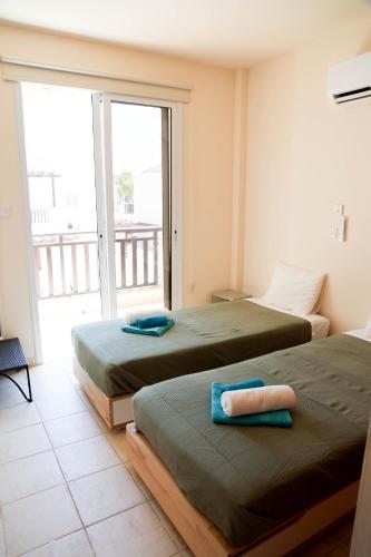 two beds in a room with a balcony at Agesilaos Seaview 33 in Ayia Napa