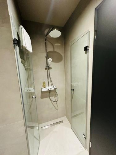 a shower in a bathroom with a glass shower stall at Taunus Suites in Oberursel