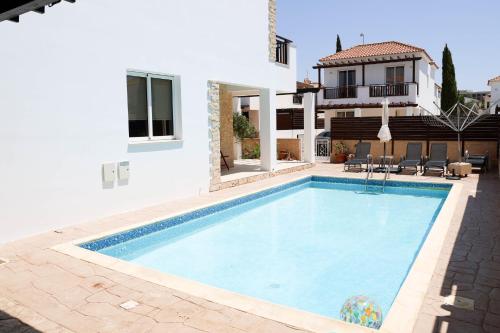 a swimming pool in front of a house at Agesilaos Seaview 33 in Ayia Napa