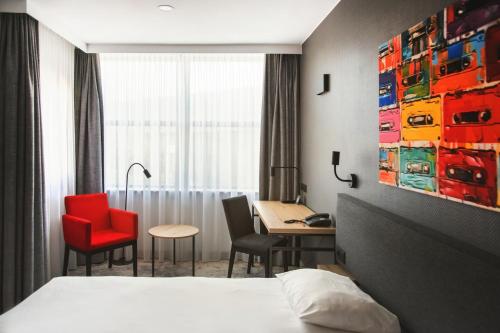 a hotel room with a bed and a table and chairs at Qubus Hotel Gorzów Wielkopolski in Gorzów Wielkopolski