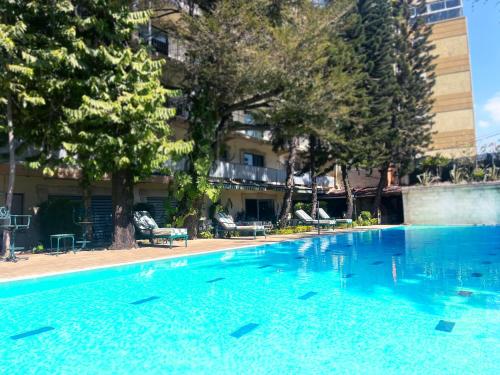 a large blue swimming pool in front of a building at Sunny Garden in Antananarivo