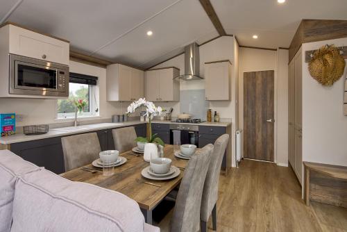 a kitchen and dining room with a wooden table and chairs at Billing Aquadrome Holiday Park in Great Billing