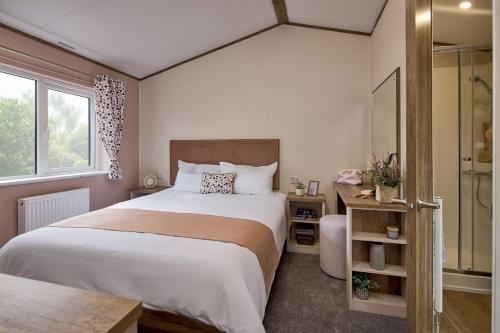 a bedroom with a large bed and a shower at Billing Aquadrome Holiday Park in Great Billing