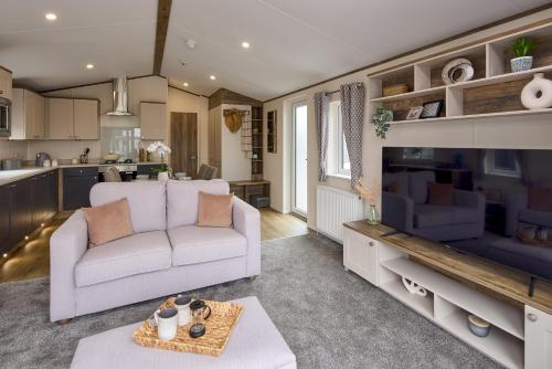 a living room with a couch and a kitchen at Billing Aquadrome Holiday Park in Great Billing