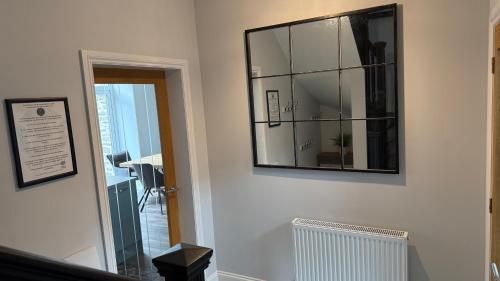 a mirror hanging on a wall in a room at The Bakehouse - by Caithness Luxury Apartments NC500 - 5 Bedroom Luxury Holiday Home - Sleeps Work teams upto 5 & holiday makers upto 10 in Wick