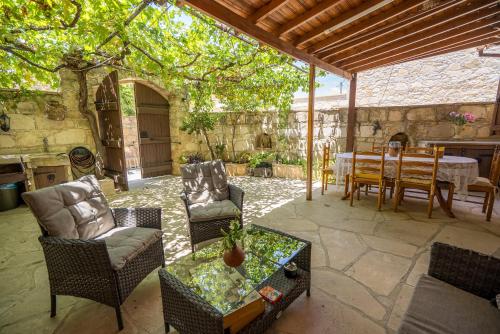 an outdoor patio with a table and chairs and a table and a dining room at Maison Des Vignes Lofou in Lofou