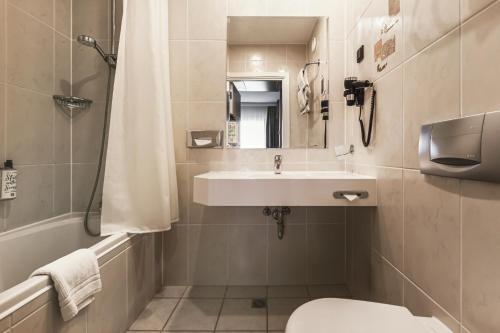 a bathroom with a sink and a toilet at Qubus Hotel Gorzów Wielkopolski in Gorzów Wielkopolski