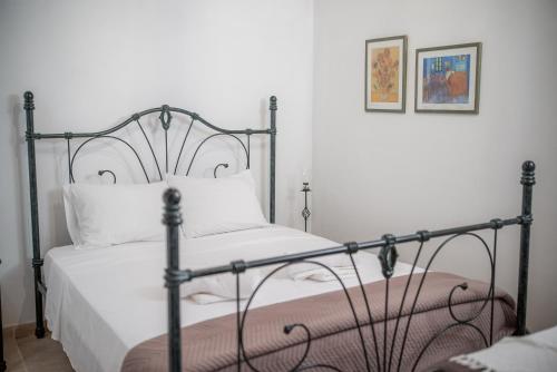 a bedroom with a bed with a metal frame at Maison Des Vignes Lofou in Lofou