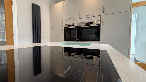 a kitchen with a stove and a microwave at The Bakehouse - by Caithness Luxury Apartments NC500 - 5 Bedroom Luxury Holiday Home - Sleeps Work teams upto 5 & holiday makers upto 10 in Wick