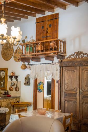 a dining room with a table and a wooden cabinet at Maison Des Vignes Lofou in Lofou