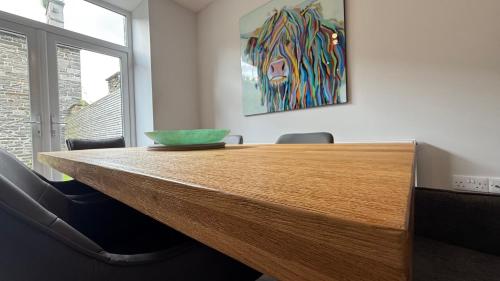 a wooden table in an office with a bowl on it at The Bakehouse - by Caithness Luxury Apartments NC500 - 5 Bedroom Luxury Holiday Home - Sleeps Work teams upto 5 & holiday makers upto 10 in Wick