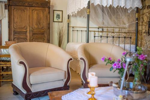 two chairs and a bed in a room with a table at Maison Des Vignes Lofou in Lofou