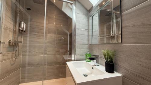 a bathroom with a white sink and a shower at The Bakehouse - by Caithness Luxury Apartments NC500 - 5 Bedroom Luxury Holiday Home - Sleeps Work teams upto 5 & holiday makers upto 10 in Wick