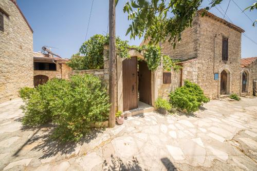 an old stone house with a wooden door at Maison Des Vignes Lofou in Lofou
