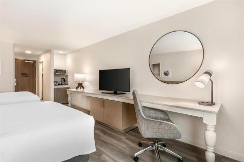 a hotel room with a desk and a mirror at Hilton Garden Inn Montgomery - EastChase in Montgomery