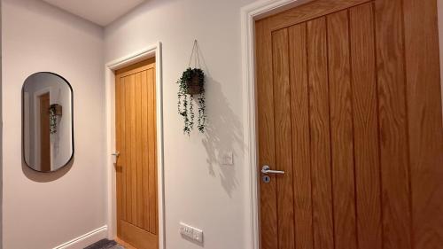 a hallway with a wooden door and a mirror at The Bakehouse - by Caithness Luxury Apartments NC500 - 5 Bedroom Luxury Holiday Home - Sleeps Work teams upto 5 & holiday makers upto 10 in Wick
