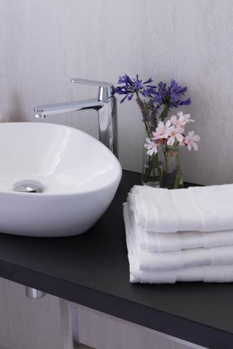 a white sink sitting on a black counter with towels at Il cubo di Aligi in Missaglia
