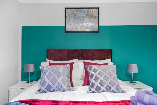 a bedroom with a bed with a green wall at Detached 6 Bedroom Cambridgeshire Abode - Pets in Whittlesford