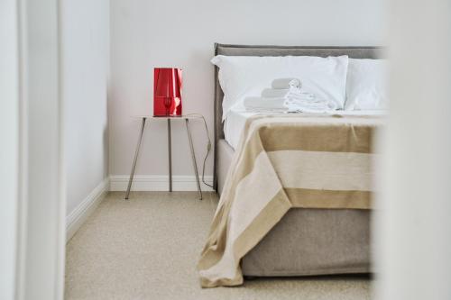 a bed with a red lamp on a side table at Villa in centro con Giardino e Parcheggio - La Casa della Giuliana in Santarcangelo di Romagna