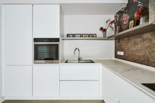 a white kitchen with white cabinets and a sink at Villa in centro con Giardino e Parcheggio - La Casa della Giuliana in Santarcangelo di Romagna