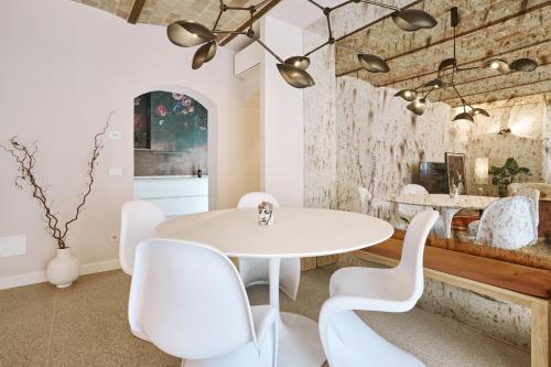 a dining room with a white table and white chairs at Villa in centro con Giardino e Parcheggio - La Casa della Giuliana in Santarcangelo di Romagna