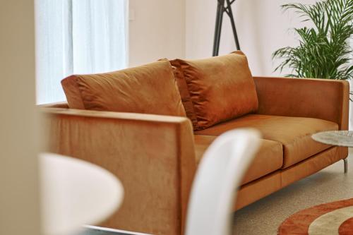a brown couch in a living room with a laptop at Villa in centro con Giardino e Parcheggio - La Casa della Giuliana in Santarcangelo di Romagna