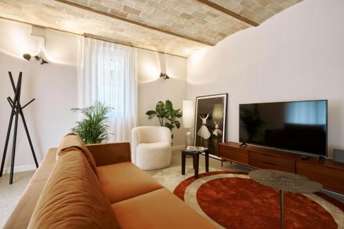 a living room with a couch and a flat screen tv at Villa in centro con Giardino e Parcheggio - La Casa della Giuliana in Santarcangelo di Romagna
