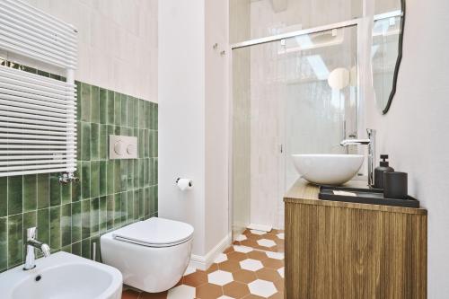 a bathroom with a white toilet and a sink at Villa in centro con Giardino e Parcheggio - La Casa della Giuliana in Santarcangelo di Romagna