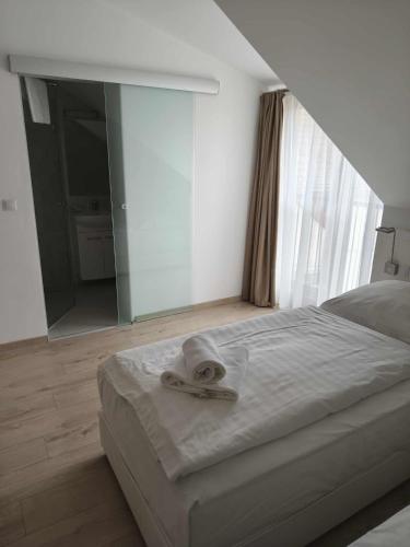 a bedroom with a bed with a towel on it at Erhardt Panzió in Sopron