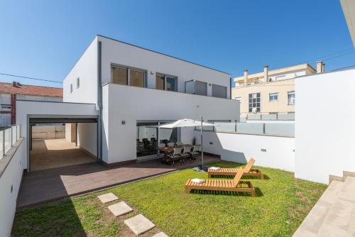 an external view of a house with a backyard at Stylish Home w/ Garage & Terrace by HostWise in Senhora da Hora