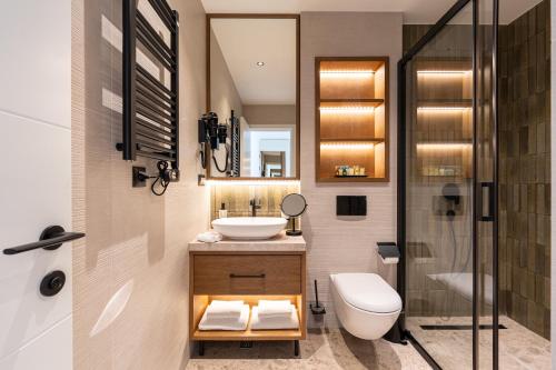 a bathroom with a sink and a toilet and a shower at Hotel Palazzo del Mare - Essenza in Kotor