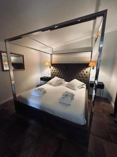 a bedroom with a canopy bed with two towels on it at La Villa Dune, Hôtel & Spa in Saint-Tropez