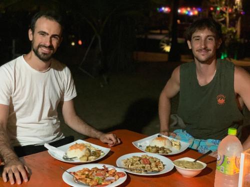 two men sitting at a table with plates of food at The Tasty Tuna Cabana in Arugam Bay