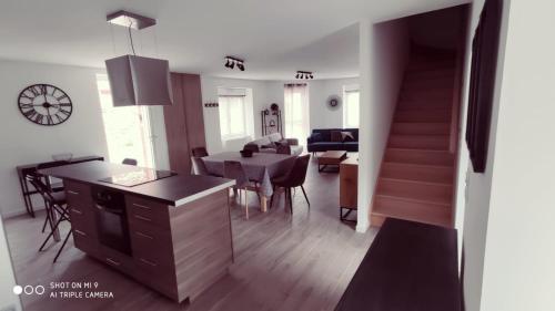 a kitchen and living room with a table and a dining room at Le gîte de Brocéliande in Saint-Malo-de-Beignon