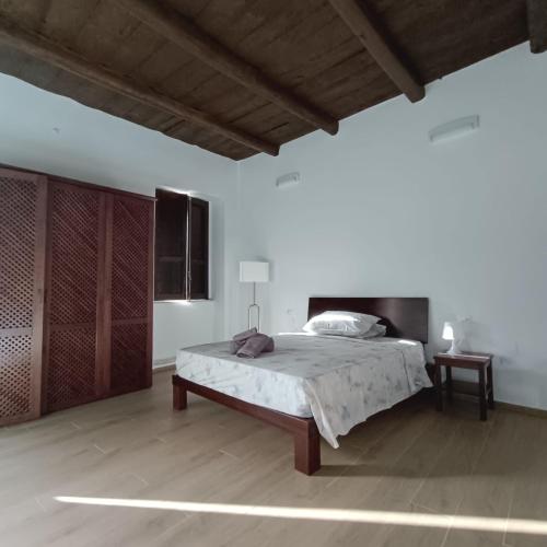 ein Schlafzimmer mit großem Bett und Holzboden in der Unterkunft Palazzo Menghina in Casaletto Spartano