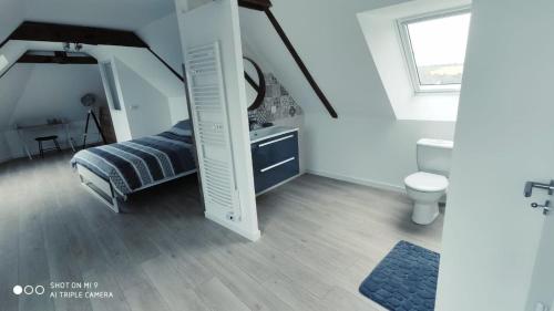 a bedroom with a bed and a bathroom with a mirror at Le gîte de Brocéliande in Saint-Malo-de-Beignon