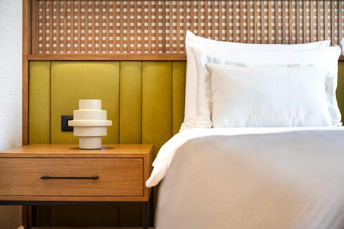 a bedroom with a bed and a nightstand with a white bedspread at Hotel Palazzo del Mare - Essenza in Kotor