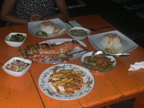 a table with plates of seafood and other foods at The Tasty Tuna Cabana in Arugam Bay