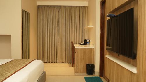 a hotel room with a bed and a television at Hotel Devdeep Porvorim in Porvorim