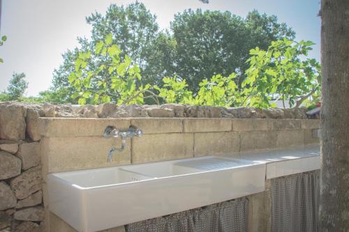 a white sink in a stone wall at Ad un passo da Cisternino - Trulli con Camino, Foresta e BBQ in Cisternino