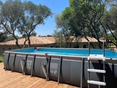 une grande piscine sur une terrasse avec une échelle dans l'établissement Villa de Standing avec vue montagne, proche de Porto-Vecchio, à Porto-Vecchio