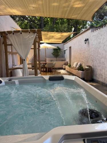a jacuzzi tub in a backyard with an umbrella at La Villa Dune, Hôtel & Spa in Saint-Tropez