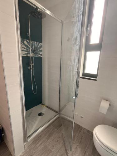 a bathroom with a shower with a toilet and a window at Casa Buonanotte in San Marco di Castellabate